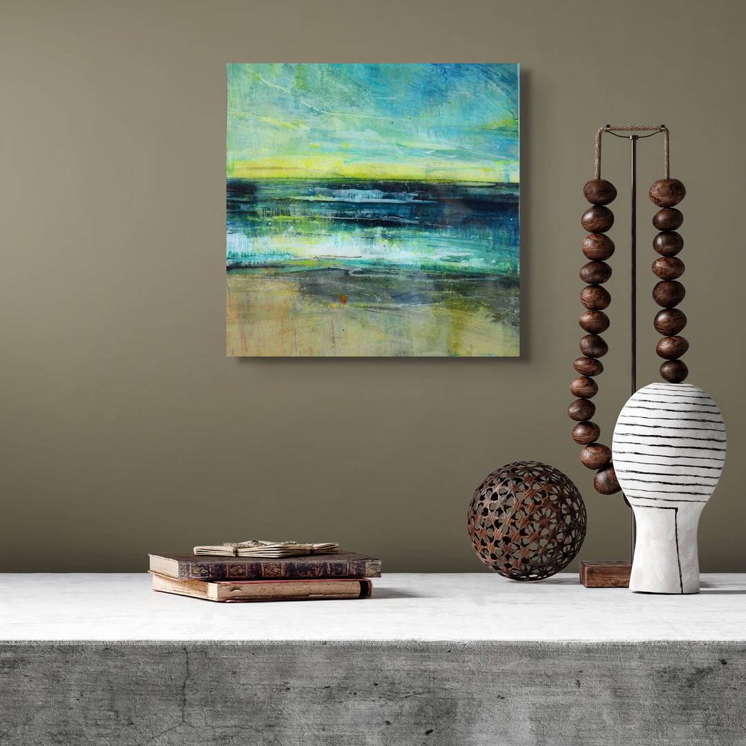 Square abstract painting of a beach on a wall.